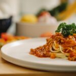 appetizing spaghetti pasta with bolognese sauce served in kitchen