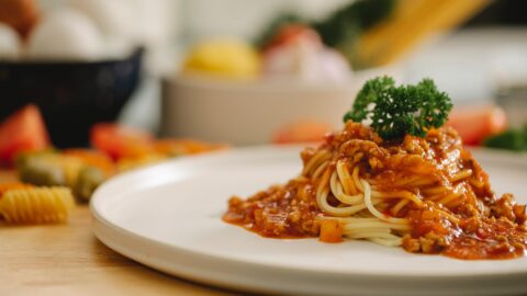 appetizing spaghetti pasta with bolognese sauce served in kitchen