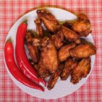 chili peppers and fried chicken wings on plate