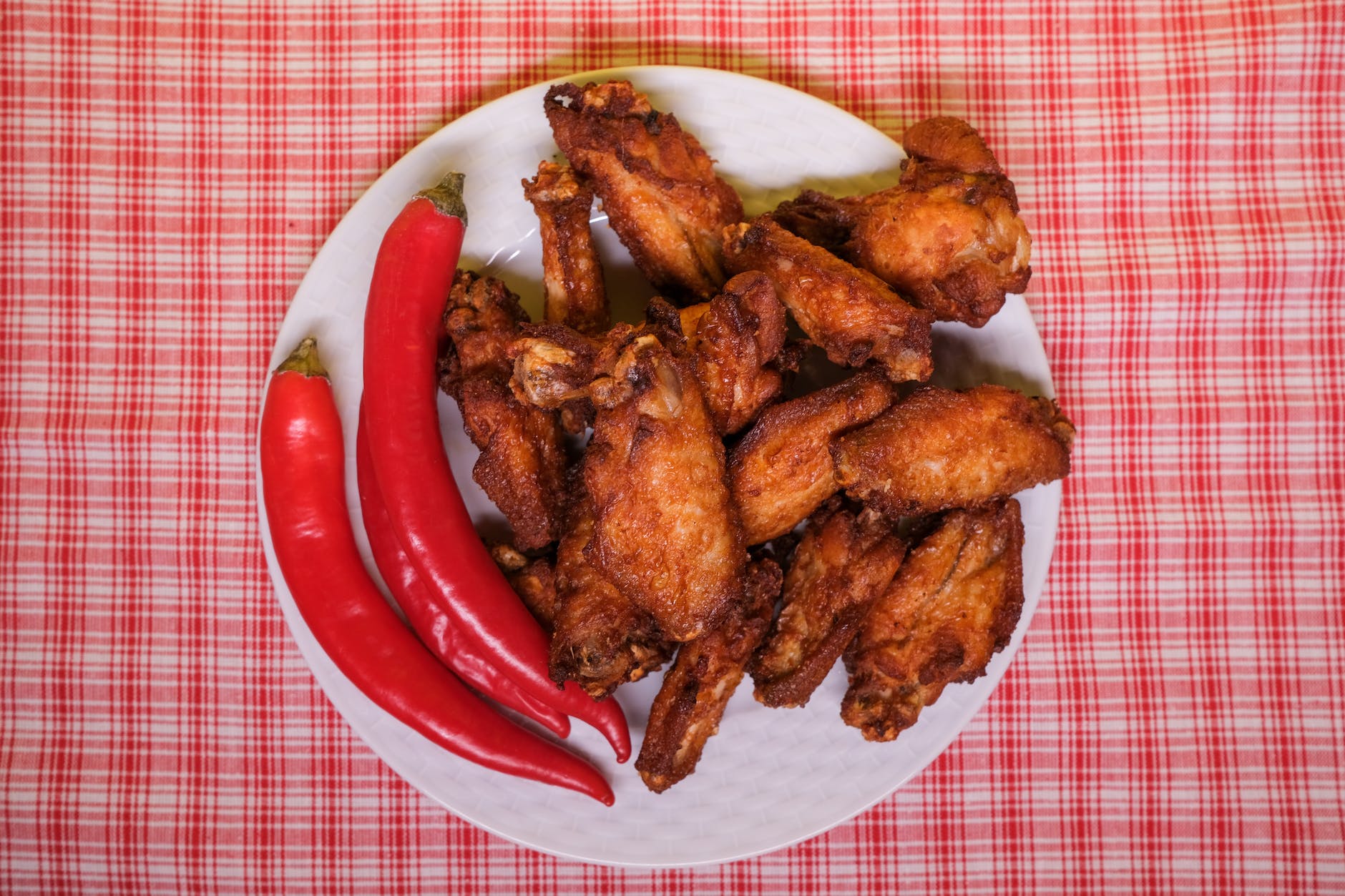 chili peppers and fried chicken wings on plate